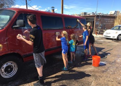 Family working together to wash cars.